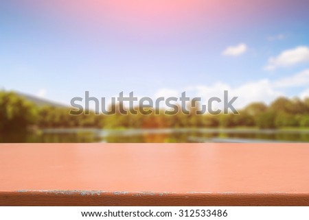 desk space and beautiful river with mountains and sun shine background for present product