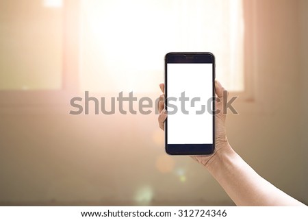 Hand holding smartphone device and blur background.