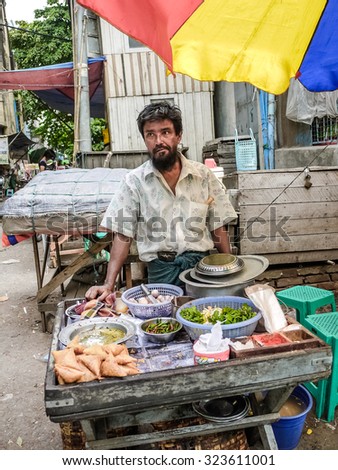 MANTHALAY, MYANMAR - Circa JULY 2012 - Nearby local business area, a man hawker was selling food.