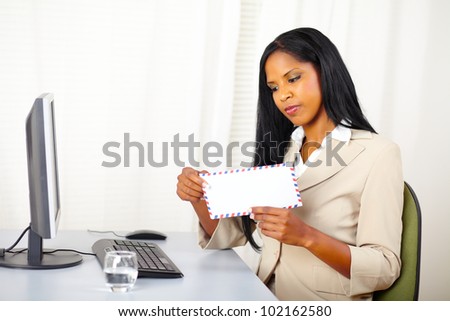 Portrait of a beautiful young executive woman at work while open a letter