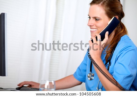 Portrait of a charming pretty nurse looking on computer at hospital