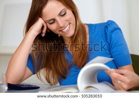 Portrait of a pretty blonde student woman smiling and learning at home indoor