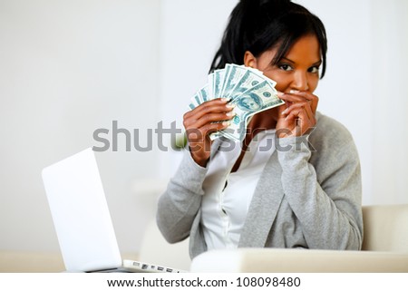 Portrait of an ambitious excited black woman with money