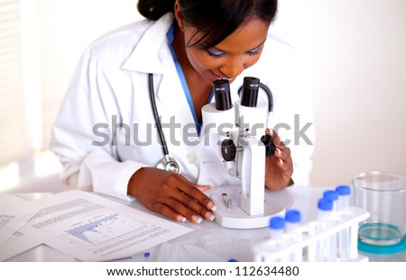 Medical doctor female working with a microscope at laboratory