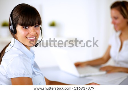 Smiling young woman with headset working at call center