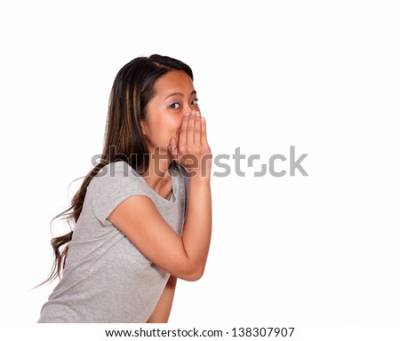 Portrait of an asiatic charming young woman whisper a secret on isolated background