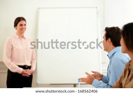 Portrait of beautiful professional woman smiling and looking at colleagues team on office meeting - copyspace