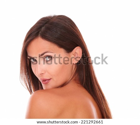 Head and shoulders portrait of charming latin woman showing her good skincare with nude shoulders while looking at camera on isolated studio