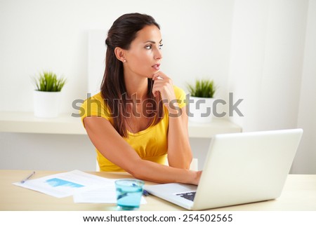 Adult female employee of a business company working on her computer in the office
