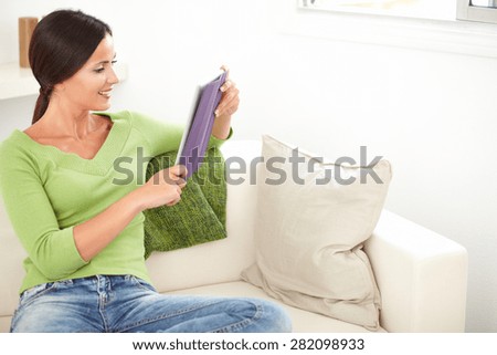 Three quarter length portrait of a young female smiling while using a tablet - copy space