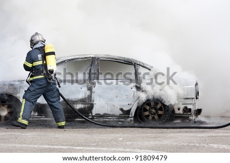 a firefighter putting out a car that was burning
