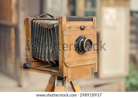 Old wooden camera on a blurred background.