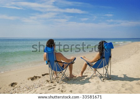 couple relaxing in the chairs on the beach