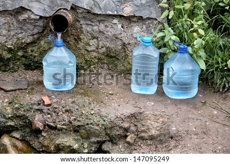 Filling by water of bottles from a source