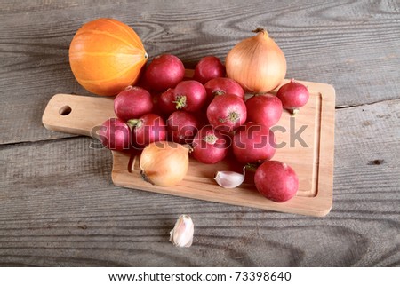 Onions garlic  garden radish on a table from unplaned boards