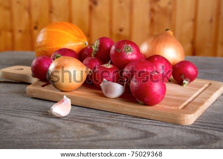 Onions garlic  garden radish on a table from unplained boards