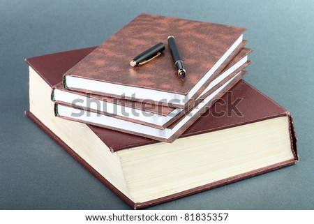 Thick book volume notebooks and pen on a table