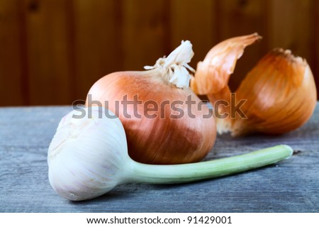 garlic onions and peel on a table from unplaned boards