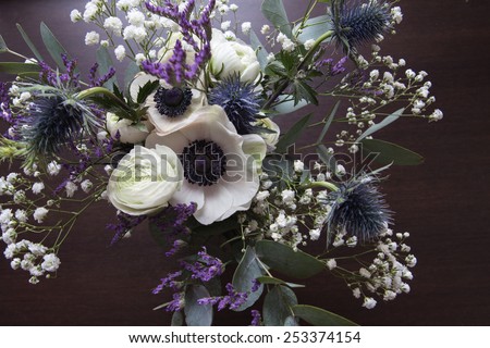 White violet bouquet of anemones and ranunculuses on dark background