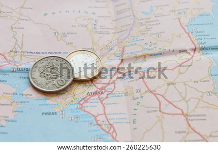 One Euro coin and greek drachma on a Greek Map. Concept of Greece financial Crisis.