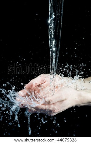 Hand and creative splashing water on black background