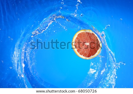 Fresh orange and splashing blue water