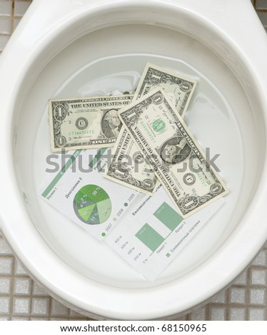 Dollars getting ready to be flushed down the toilet. Photo for  payments, finance, taxes, wasteful spending and any other financial inference