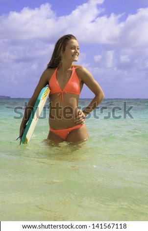 girl in bikini with her boogie board in hawaii