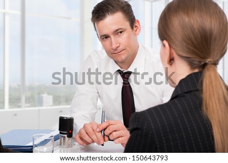Agent (or notary public) signing documents with young woman