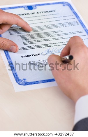 notary signing a power of attorney, focus is on the tip of the pen. Document was created by the photographer.