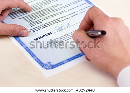 notary signing a power of attorney, focus is on the tip of the pen