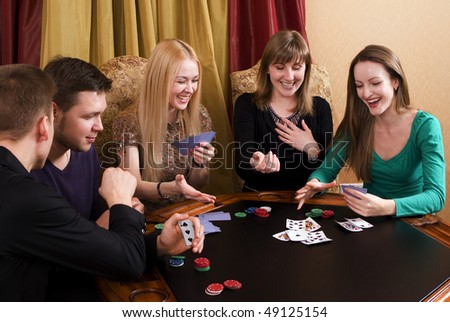 Group of young adults (three girls and two guys) playing cards