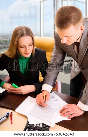 Two contemporary business people in office discussing work