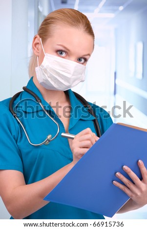 young blond in medical gown and a stethoscope and file folder in an hospital