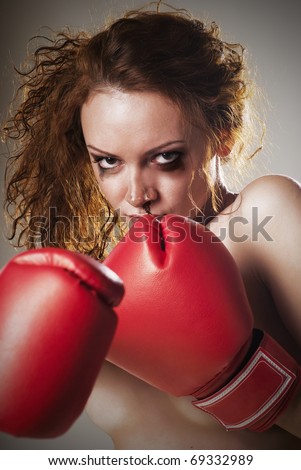 Strong determined angry woman face with fists in boxing gloves