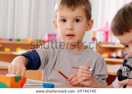 preschooler boy 4 years old drawing in classroom