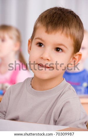 preschooler boy 4 years old listening a lesson in classroom