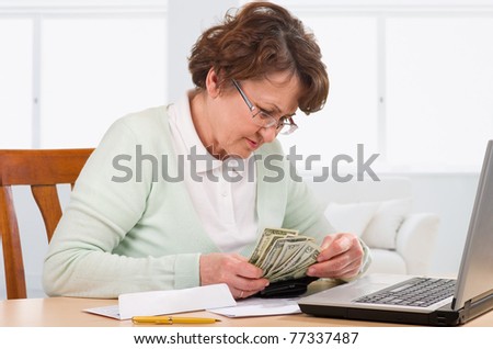 Elderly woman with wallet of money worry about bill notice.