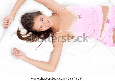 Young beautiful girl lying on bed wake up in morning