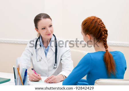 Doctor advises woman patient and showing prescription