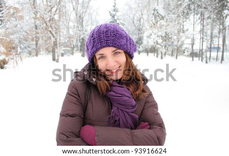 Happy healthy young woman in a park covered with snow