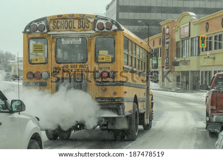Sudbury, Ontario, Canada February 15th 2014. School bus in traffic on a snowy Canadian street at -38 Celsius or -36.4 Fahrenheit Image taken on February 15th 2014 on Paris st, Sudbury Ontario, Canada