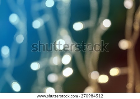 Beautiful defocused LED lights filtered bokeh abstract with blue-green-brown tone background.