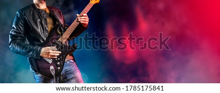 Guitar player performs on stage. Rock guitarist plays solo on an electric guitar. Artist and musician performs like rockstar.  Foto stock © 