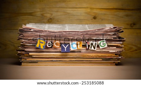 stack of old newspapers labeled recycling