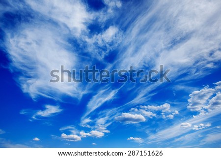 Horizontal image of white fluffy clouds on blue spring sky background.