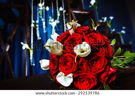 Closeup image of red roses wedding flowers  bouquet at blue interior studio background.