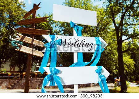 Wedding decor. Wooden desk with the inscription Wedding and blue knots.