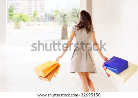 young woman with shopping bags, smiling and  walking