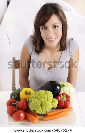 young woman with raw vegetable smiling and looking in camera
